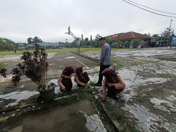 Tingkatkan Kedisiplinan,Guru piket MAN 1 Sarolangun Bina Siswa Terlambat  Melalui Aksi Bersih Lingkungan 